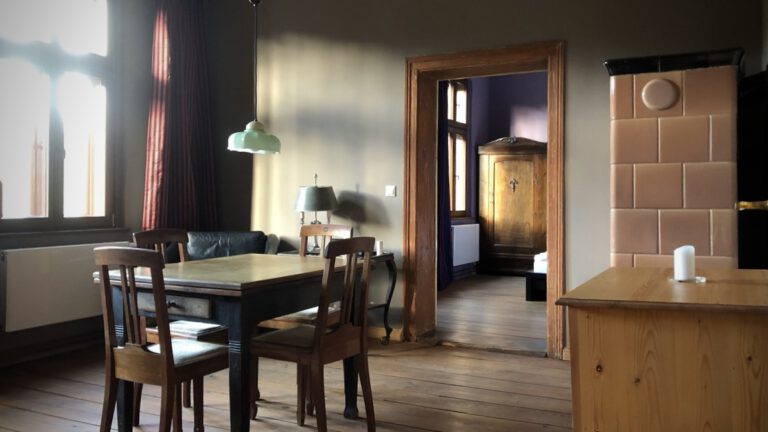 Esszimmer in der Ferienwohnung auf dem Lande mit Esstisch, Ledersessel und Kachelofen