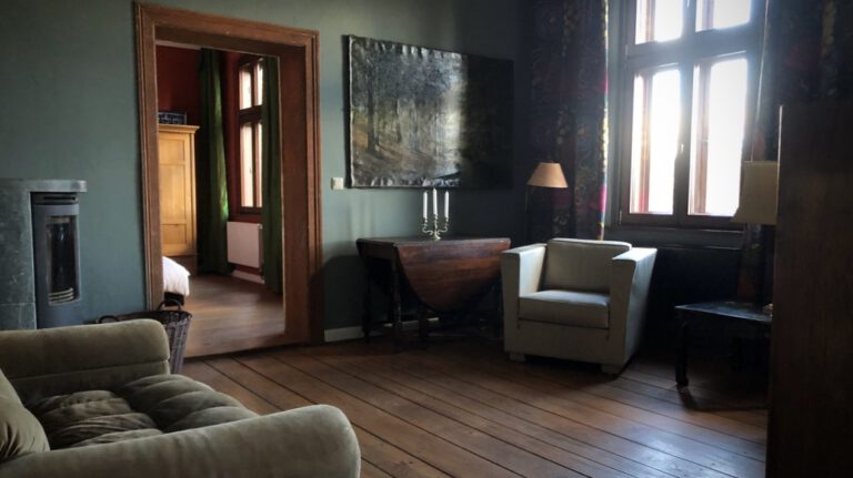 Kaminzimmer mit Ledersessel und Sofa in der Ferienwohnung Alter Bahnhof Buschhof naturnah am Waldesrand