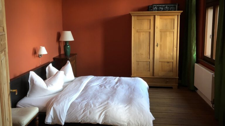 Schlafzimmer mit Doppelbett und Kleiderschrank in der Ferienwohnung Alter Bahnhof Buschhof